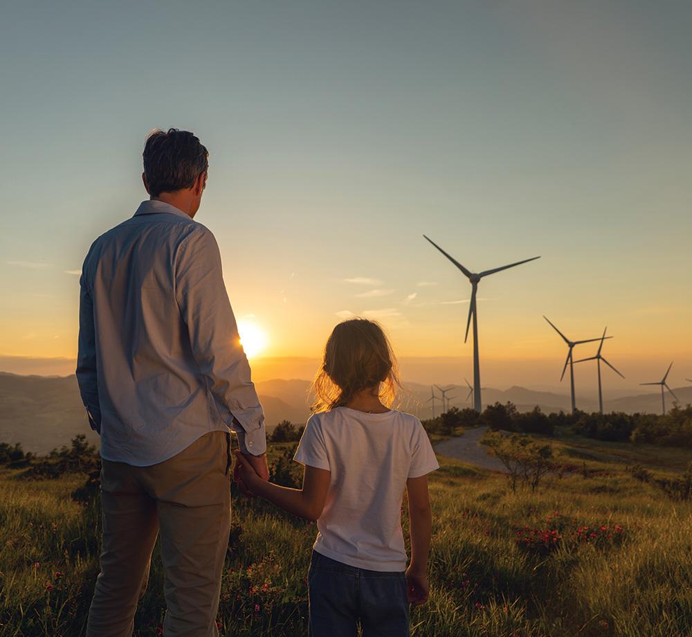 un homme et un enfant devant des éoliennes