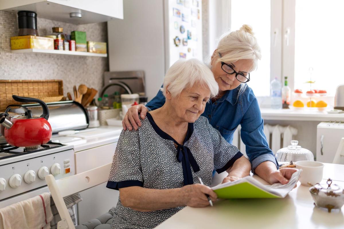 A woman helping elderly person with papers