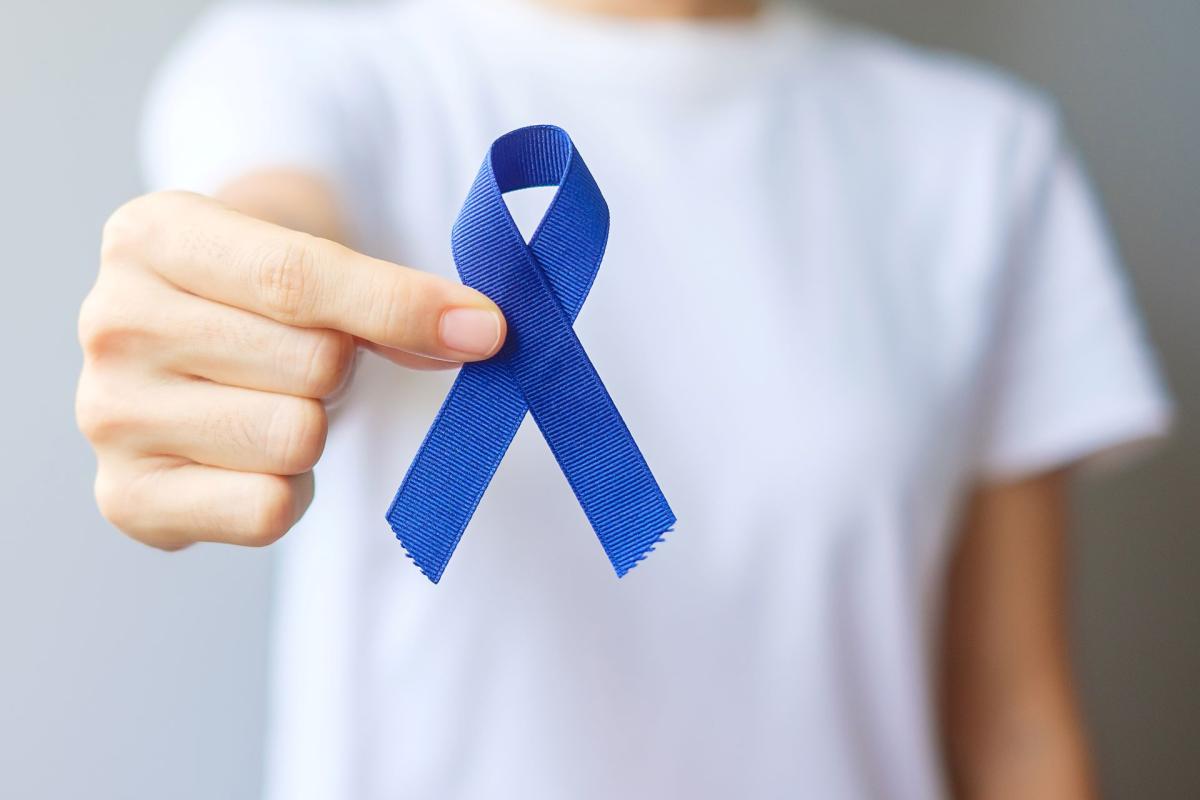 Personne tenant un ruban bleu, symbole de sensibilisation au cancer colorectal et à l’importance du dépistage