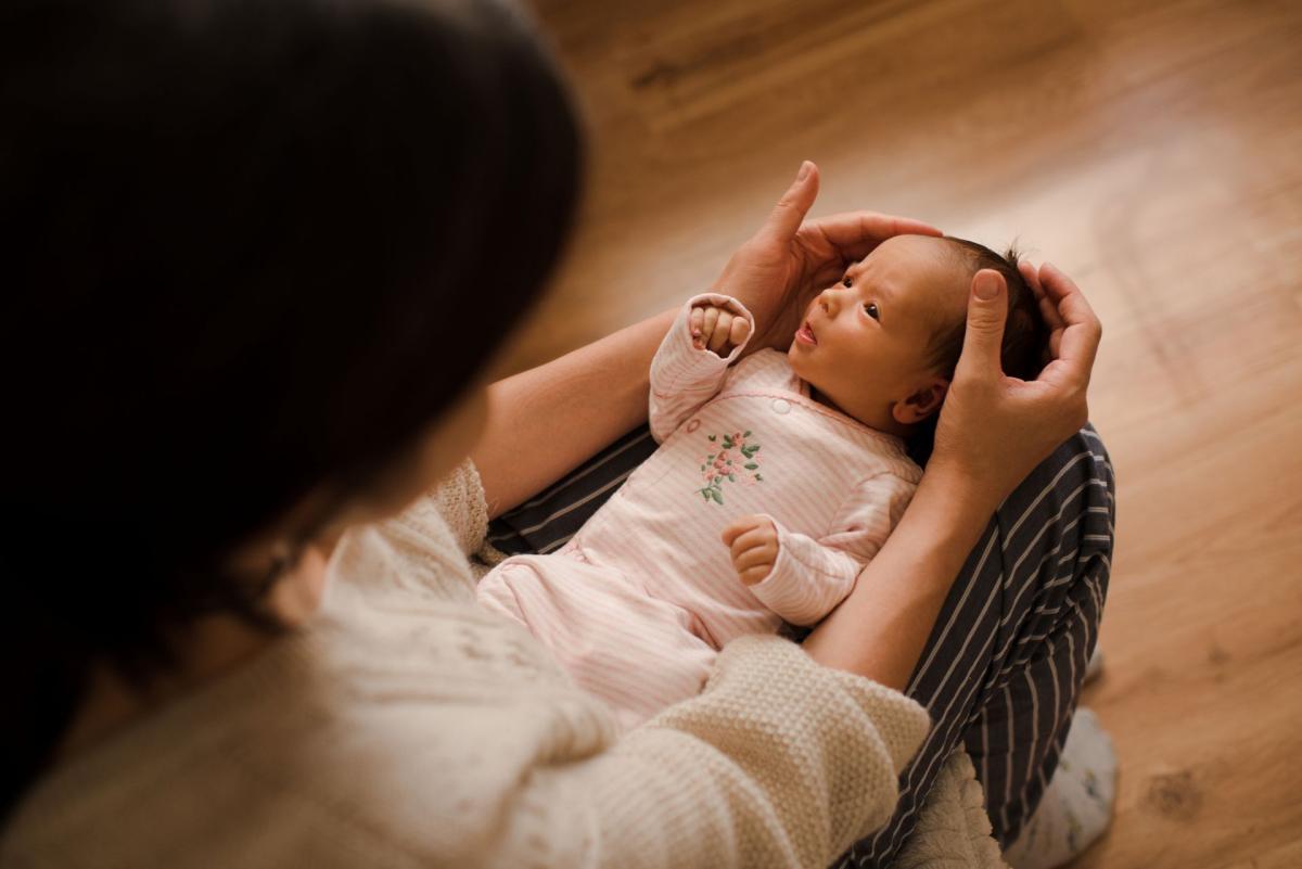 Un nourrisson allongé dans les bras d'un parent. Cette image illustre une étude sur l'utilisation des inhibiteurs de la pompe à protons chez les bébés souffrant de reflux gastro-œsophagien