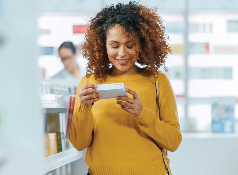 femme consulte des médicaments dans une pharmacie