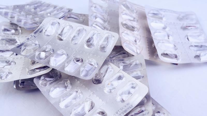 Tablettes de médicaments vides superposées sur une table blanche
