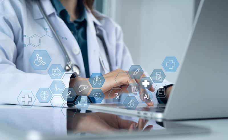 Médecin en blouse blanche utilisant un ordinateur portable, avec des icônes holographiques représentant des données de santé numériques, l'intelligence artificielle (IA), des organes humains, et des symboles médicaux.