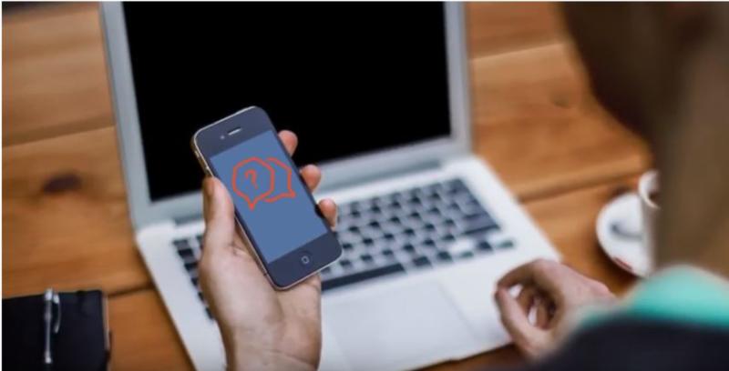 Homme assis et consultant son application Itsme depuis son smartphone / Zittende man raadpleegt zijn Itsme-applicatie op zijn smartphone