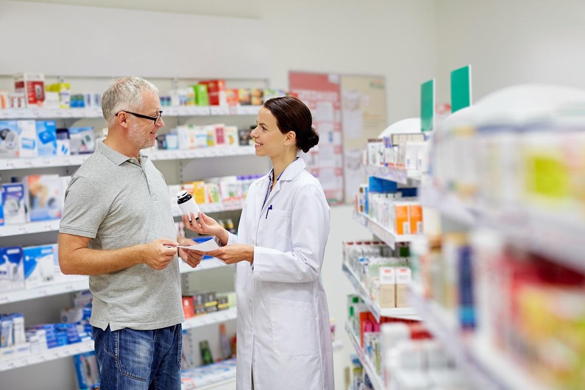 pharmacienne présentant un médicament à un homme âgé / apotheker presenteert medicijnen aan een oudere man pharmacienne présentant un médicament à un homme âgé / apotheker presenteert medicijnen aan een oudere man