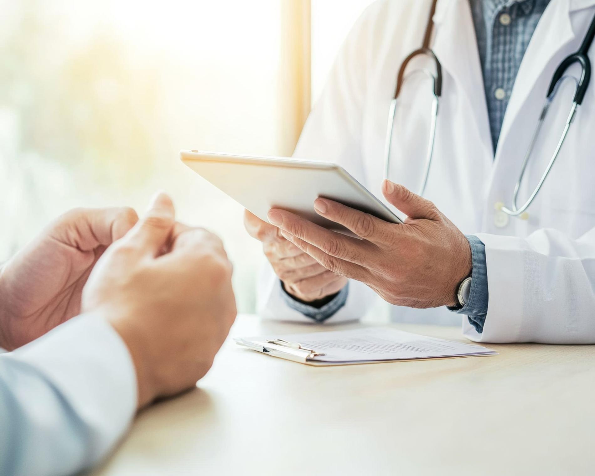 Gezondheidszorgconsulent met digitaal tablet in zonnig kantoor