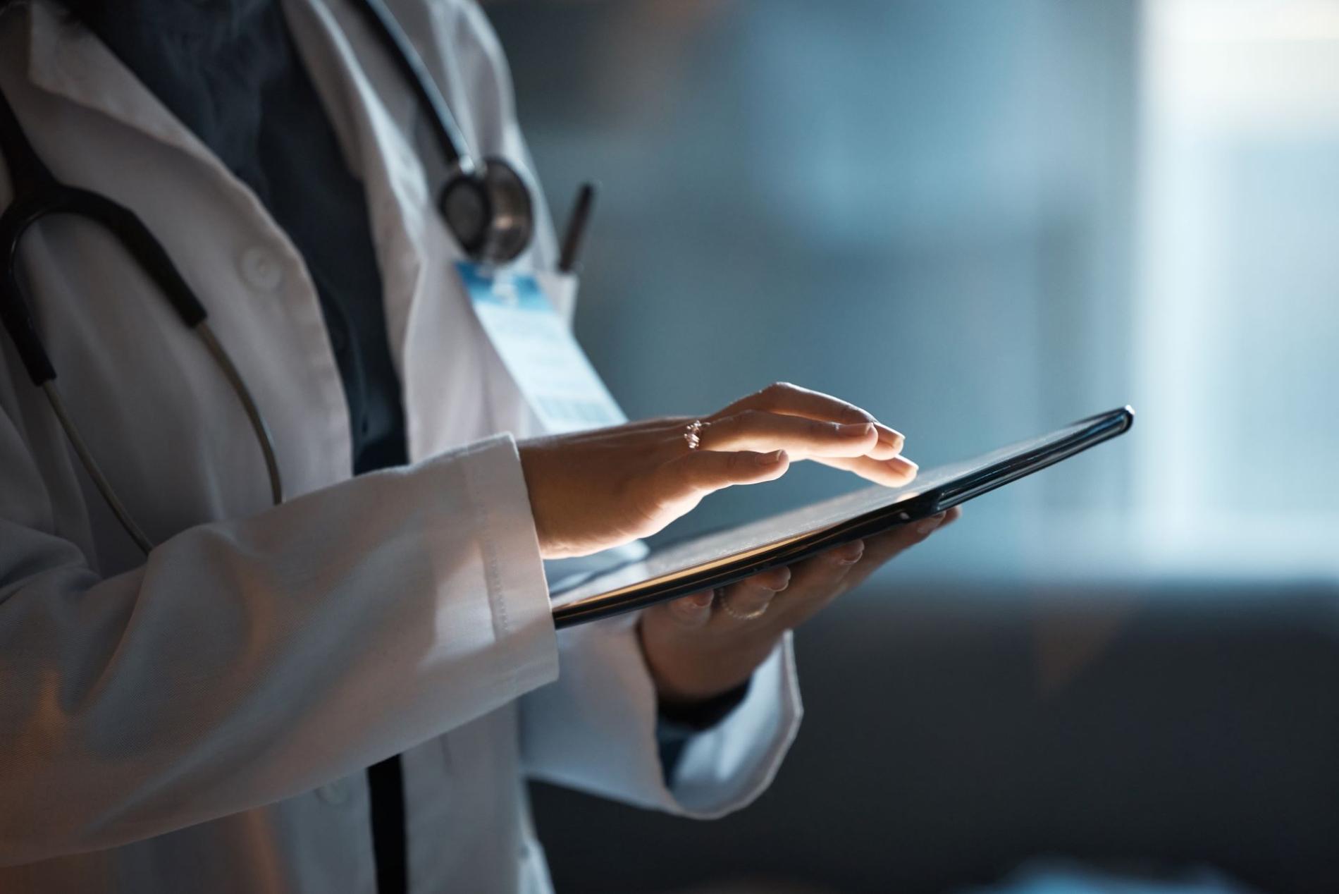 Professionnel de santé utilisant une tablette dans le cadre de la digitalisation des attestations de soins et de la transmission numérique aux mutualités.